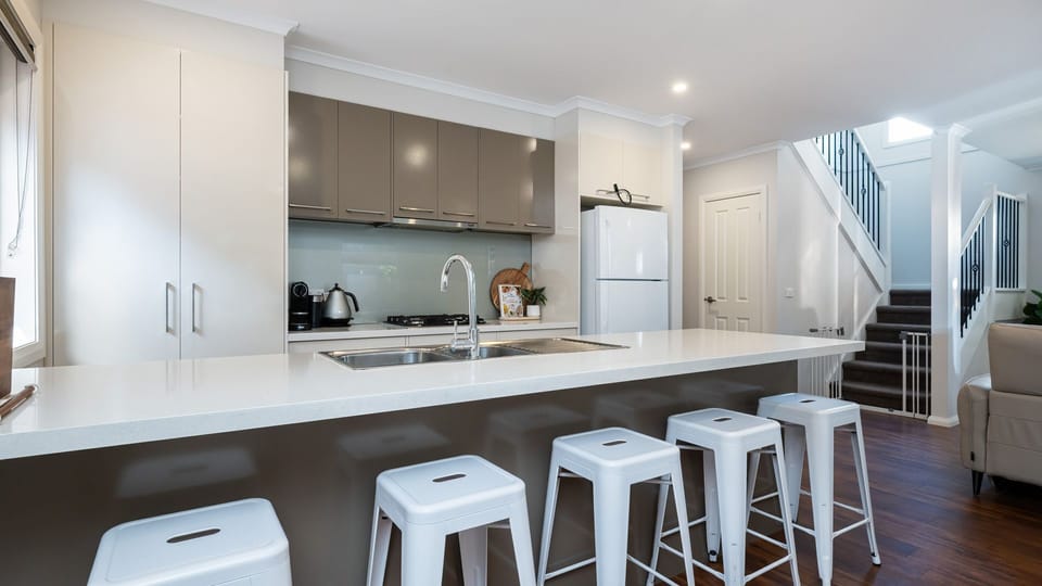 Fully equipped kitchen with breakfast bench and seating for five. 
