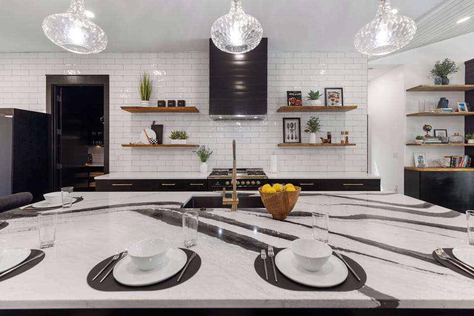Cook memorable meals in this stunning modern kitchen with marble countertops, professional appliances, and elegant pendant lighting.