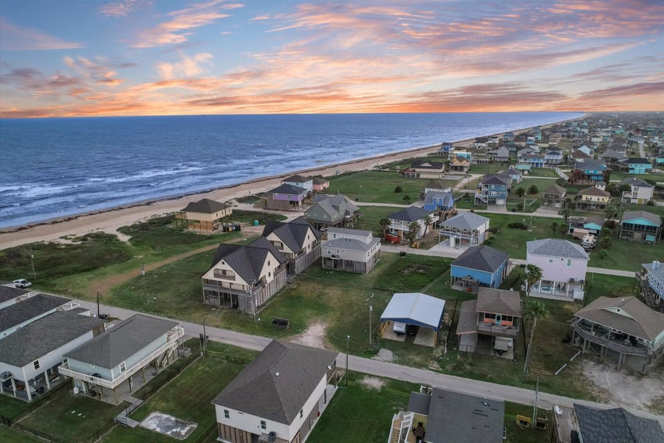 Coastal neighborhood aerial with beach access and ocean views