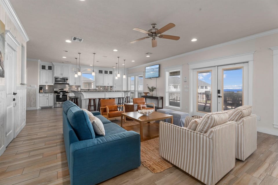 Spacious living room with multiple sofas and open kitchen view
