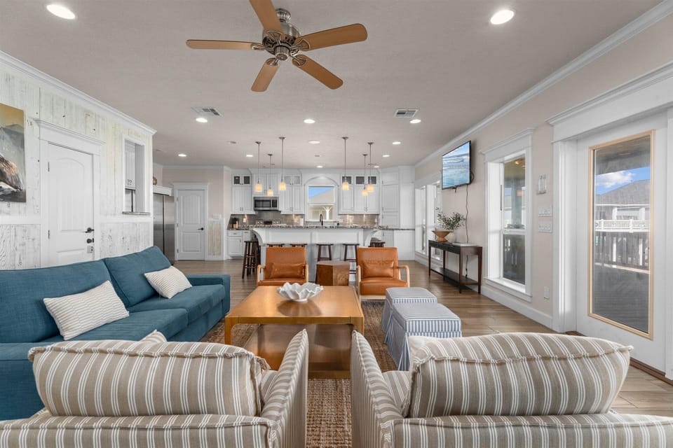 Open-concept living area with large sectional seating and ceiling fan
