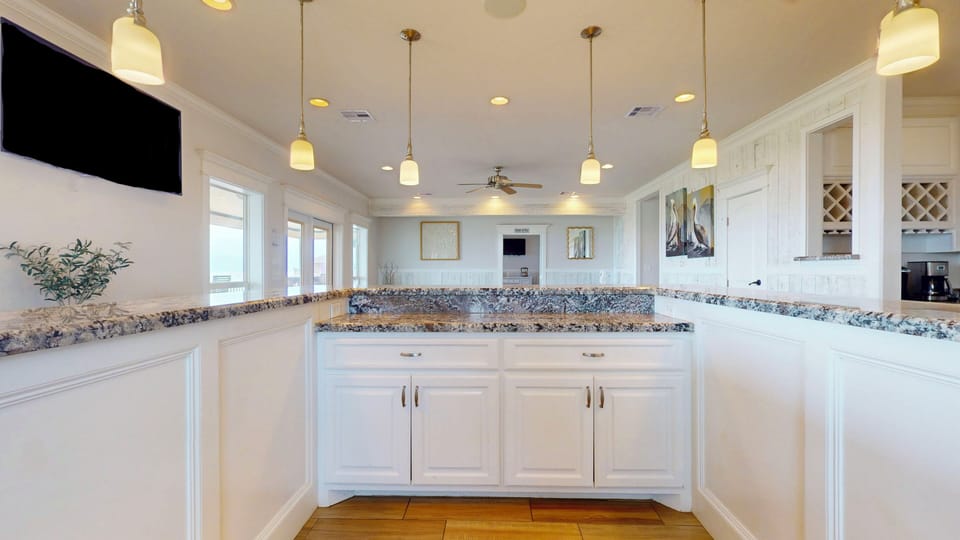 Oversized kitchen island and breakfast bar perfect for group meals and entertaining at this Crystal Beach beach house rental.