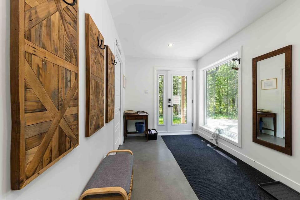 A bright entryway with forest views and convenient bench seating.