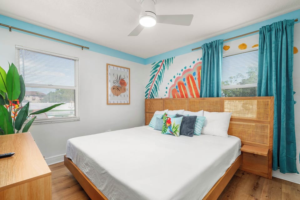 Bright bedroom with tropical wall art and natural wood furnishings