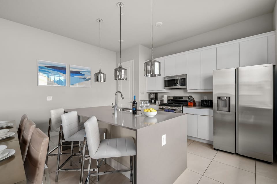 Modern kitchen with stainless steel appliances and a large island for casual dining.