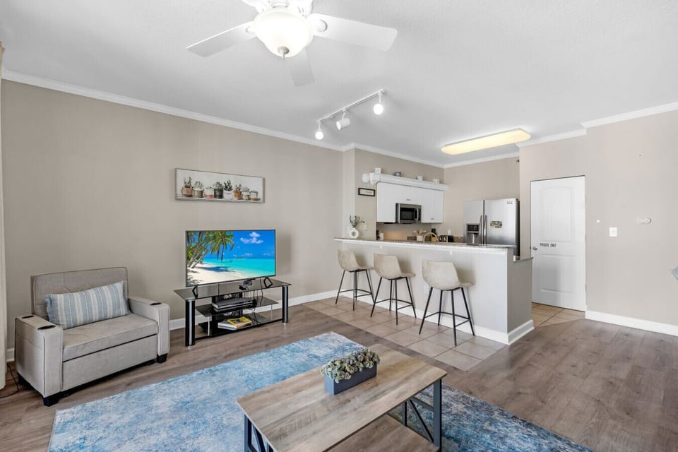 Open-concept living room with large sliding doors, natural light, and direct access to the beachfront balcony.