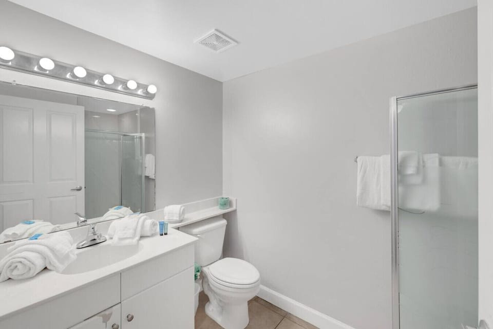 Master bathroom with shower/tub combo and a clean, coastal-inspired design for a relaxing stay.
