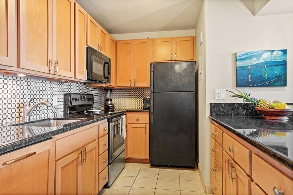 This modern kitchen offers everything you need—sleek appliances, rich wood cabinetry, and coastal charm throughout     VIR-508