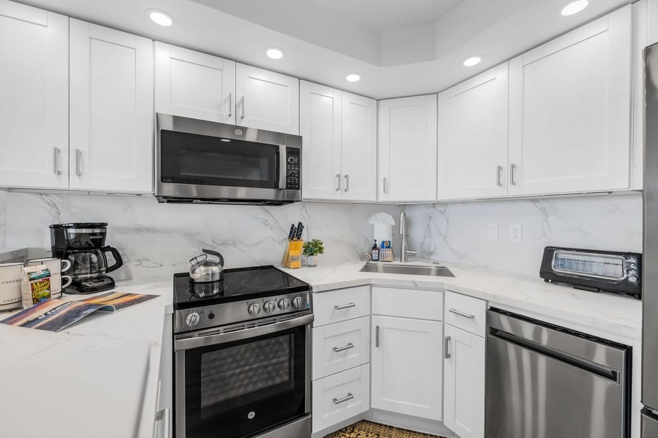White cabinetry and quartz-style counters keep the kitchen bright and functional from every angle VIR-107