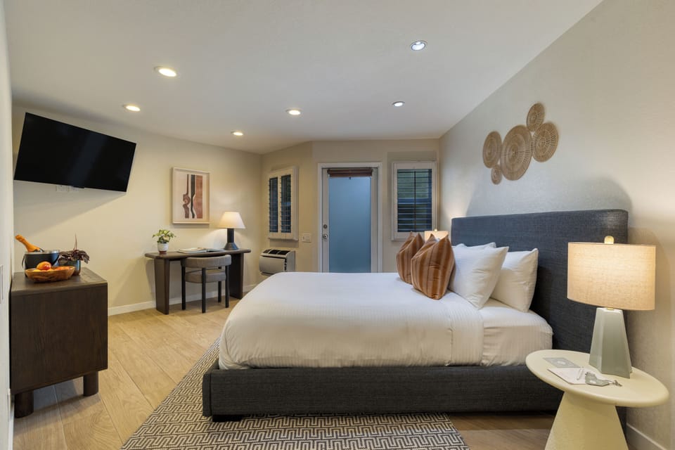 The bedroom features a plush queen bed and a TV.