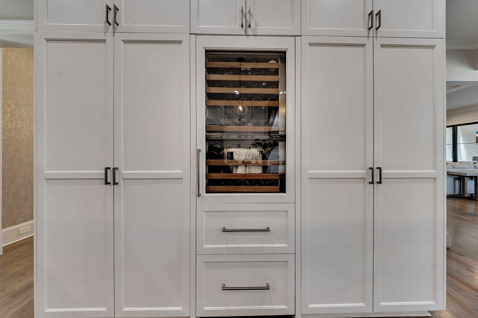 Built-in wine fridge neatly tucked into cabinetry for easy access & entertaining