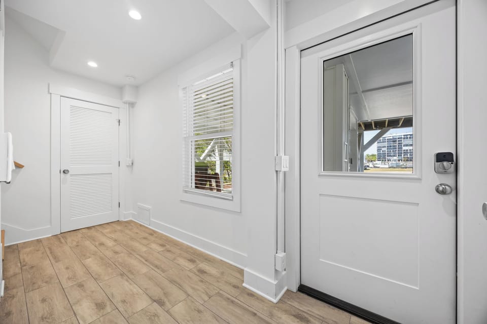 Step into your bright, welcoming entryway with gleaming hardwood floors and natural light streaming through crisp white blinds.