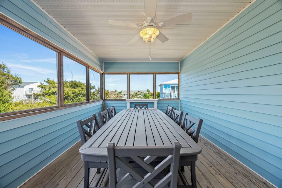 Enjoy memorable meals at your spacious screened porch dining table, where coastal breezes and treetop views create the perfect setting.