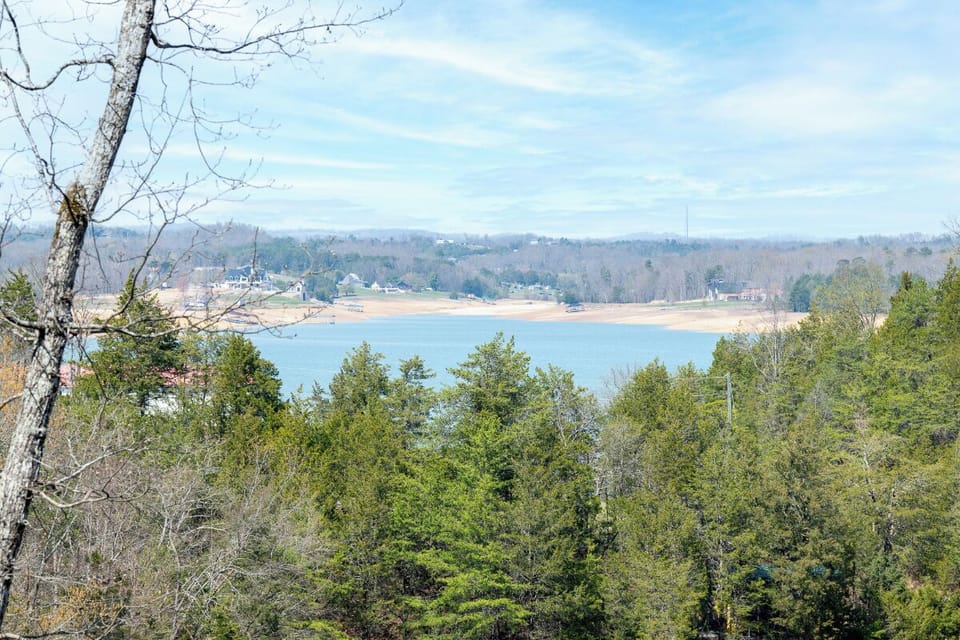 Scenic lake surrounded by lush trees and distant mountains creates a peaceful natural setting in the area.