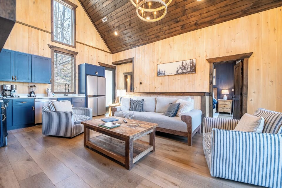Unwind in your rustic-chic living space where vaulted wood ceilings and cozy striped seating create the perfect mountain retreat atmosphere.