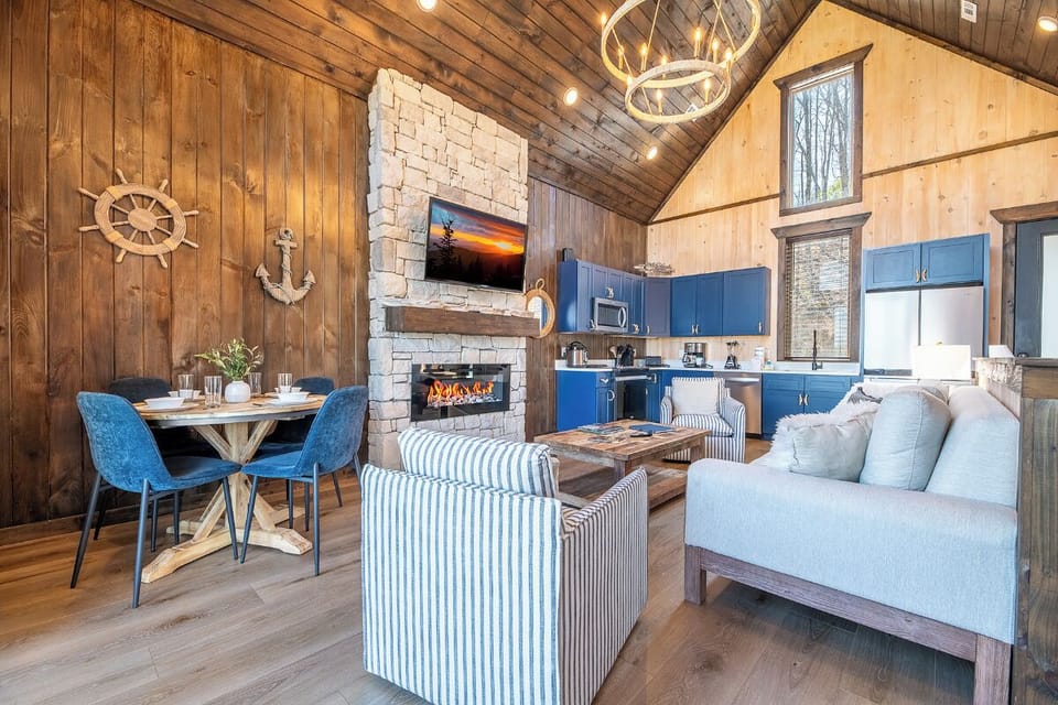 Cozy up in your retreat with crackling fireplace, modern kitchen, and charming blue accents throughout this open-concept space.