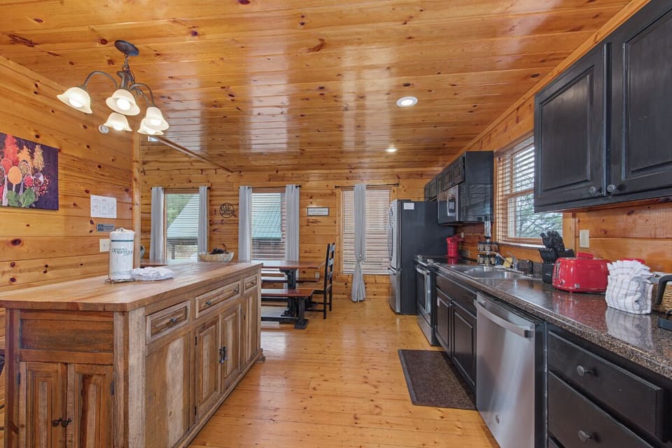 Cook your favorite meals in this rustic cabin kitchen with modern appliances and warm wood surroundings that make you feel right at home.