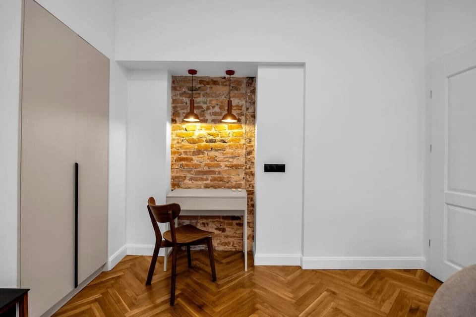Stylish Workspace Nook with Desk, Designer Lighting & Exposed Brick Wall | Book Now with RENTUJEMY.COM