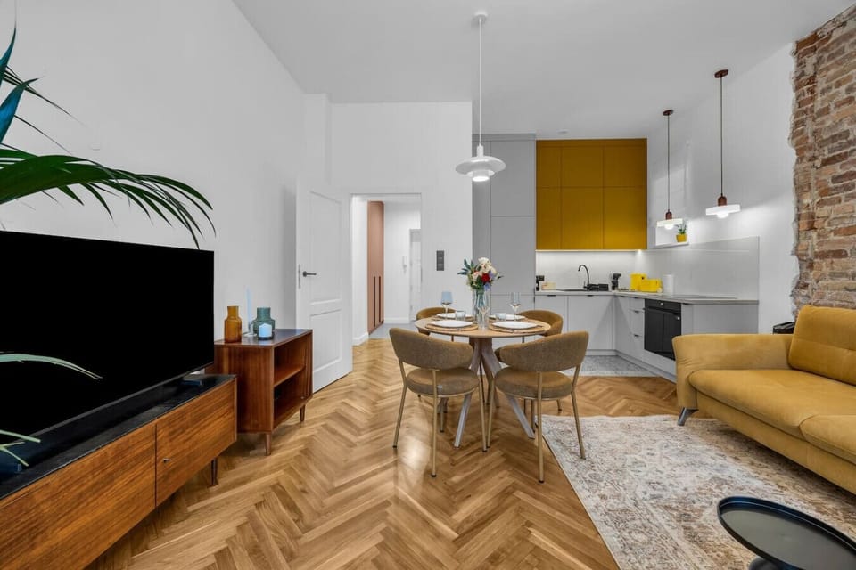 Bright Living Room with Dining Area, Balcony Access and Stylish Brick Wall Design | Book Now with RENTUJEMY.COM