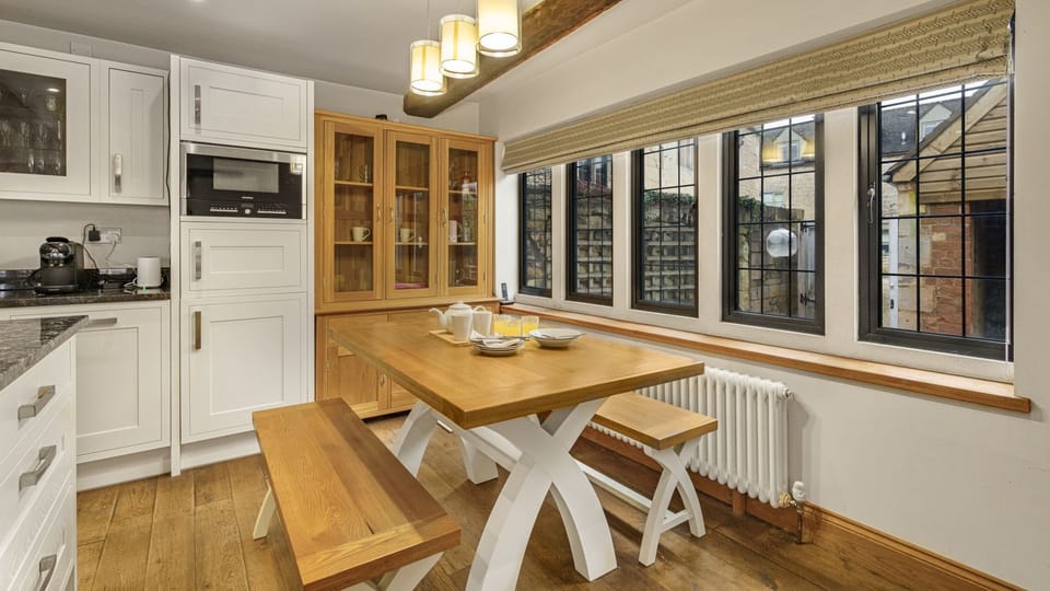 A kitchen table allows for informal dining, morning coffee or casual conversation. The space balances professional practicality with warm domestic comfort.