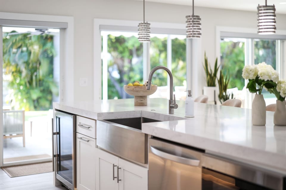 Prep meals at the spacious island, rinse fresh ingredients in the sink, and enjoy the bright view through large windows.
