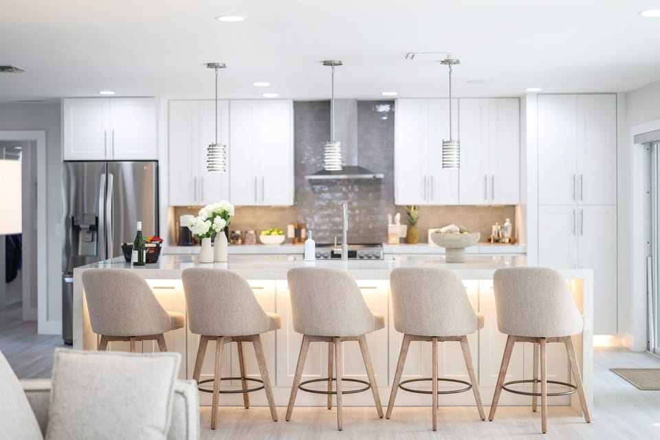 Modern kitchen with a large island and bar seating, part of a well-designed vacation home stay built for cooking, dining, and gathering.