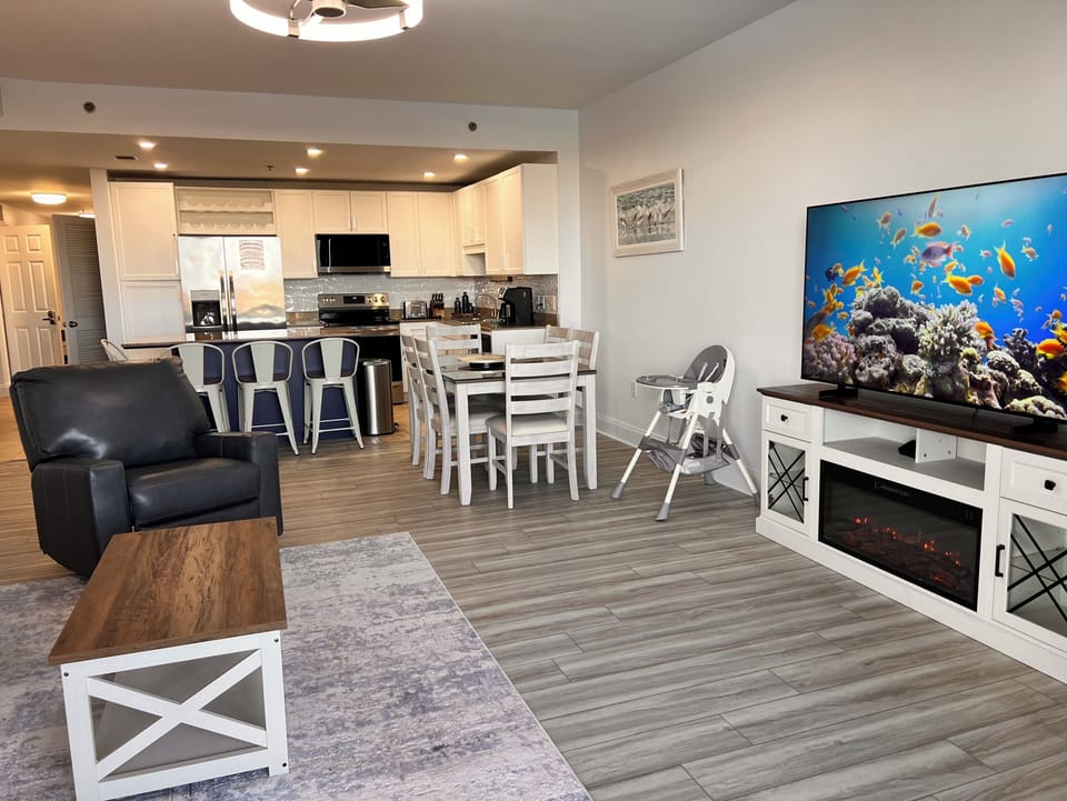 Spacious living room: Sofa, recliner, 65” Smart TV, and end tables with outlets