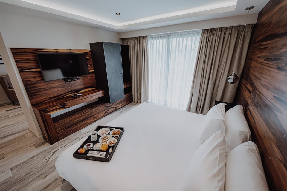 Sink into crisp linens beside warm wood accents.