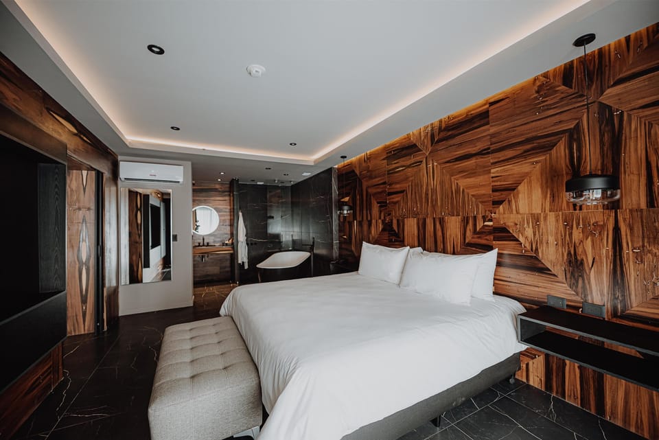 Unwind in a designer king bed with warm wood textures.