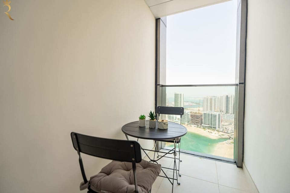 Private balcony offering stunning sea and city views, perfect for relaxing, enjoying fresh air, and taking in the vibrant skyline and waterfront scenery.