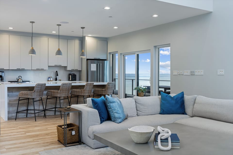 The two-story living room, framed by expansive windows overlooking the Bay and the lake.
