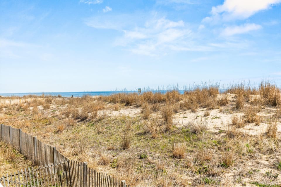 Steps to the beach with chairs, umbrellas, and games included