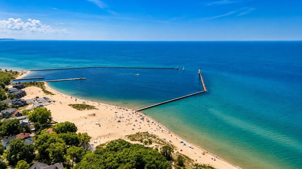 OVERVIEW:  Aerial photo of Frankfort's gorgeous beach, pier, lighthouse, and harbor from high above the house.