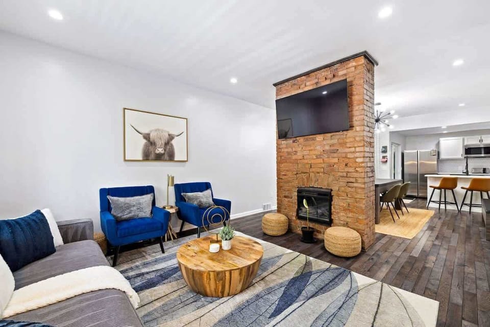 Unwind in this cozy living area featuring plush seating, a warm fireplace, and a large TV—perfect for watching the game or a movie and relaxing in comfort with friends or family.
