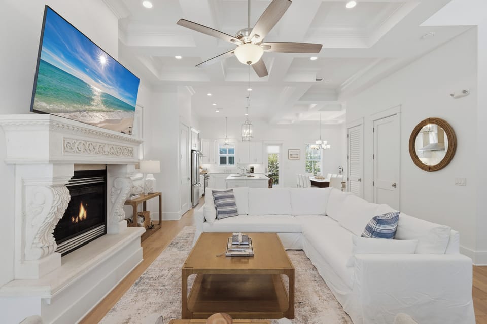 Relax in your elegant living room with cozy fireplace, stunning coffered ceilings, and open kitchen perfect for entertaining.
