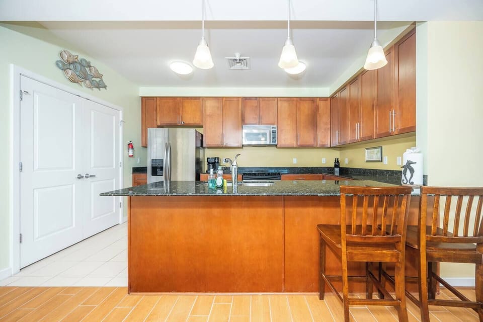 Spacious kitchen with bar seating, stainless steel appliances, and plenty of room for group meals.