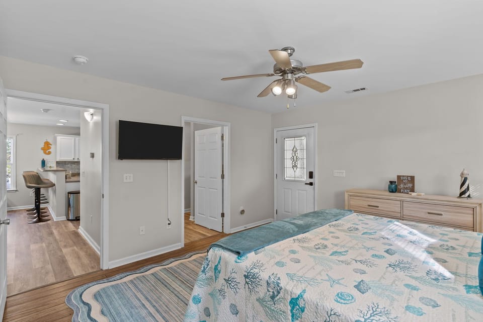 "Primary bedroom with fresh coastal décor in Oak Island rental"