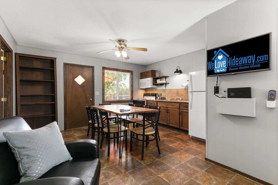 Open kitchen and dining area with dining table, full appliances, and flat-screen TV