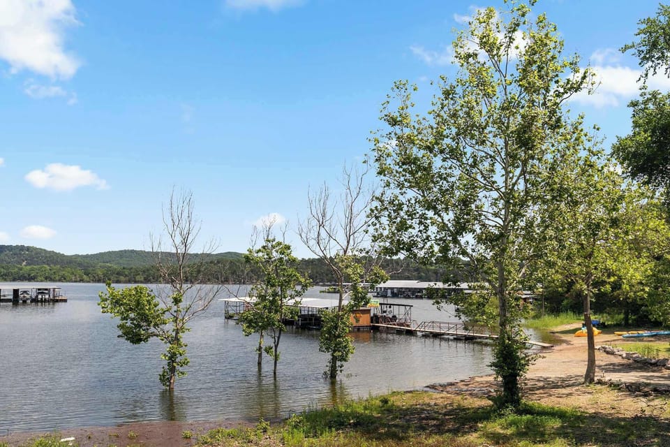 Table Rock Lake shoreline with private dock, covered boat slips, and spring foliage