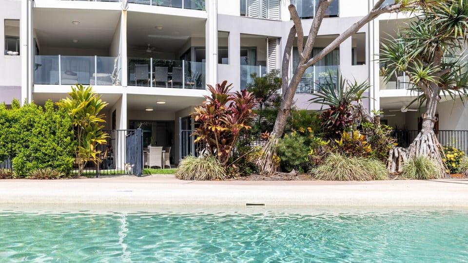 Great outdoor setup, shared pool surrounded by tropical greenery and balconies.