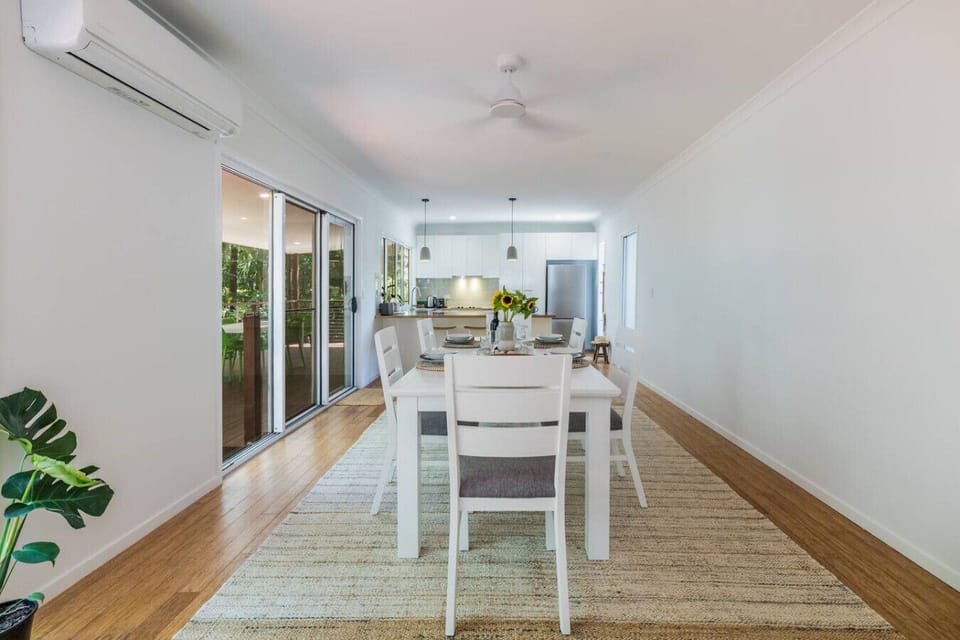 Spacious dining area with seating for six, adjoining modern kitchen and outdoor deck—perfect for family gatherings.