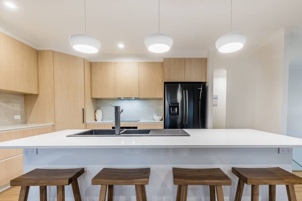 Contemporary kitchen featuring island with bar stools, modern appliances, and open layout for family meals.