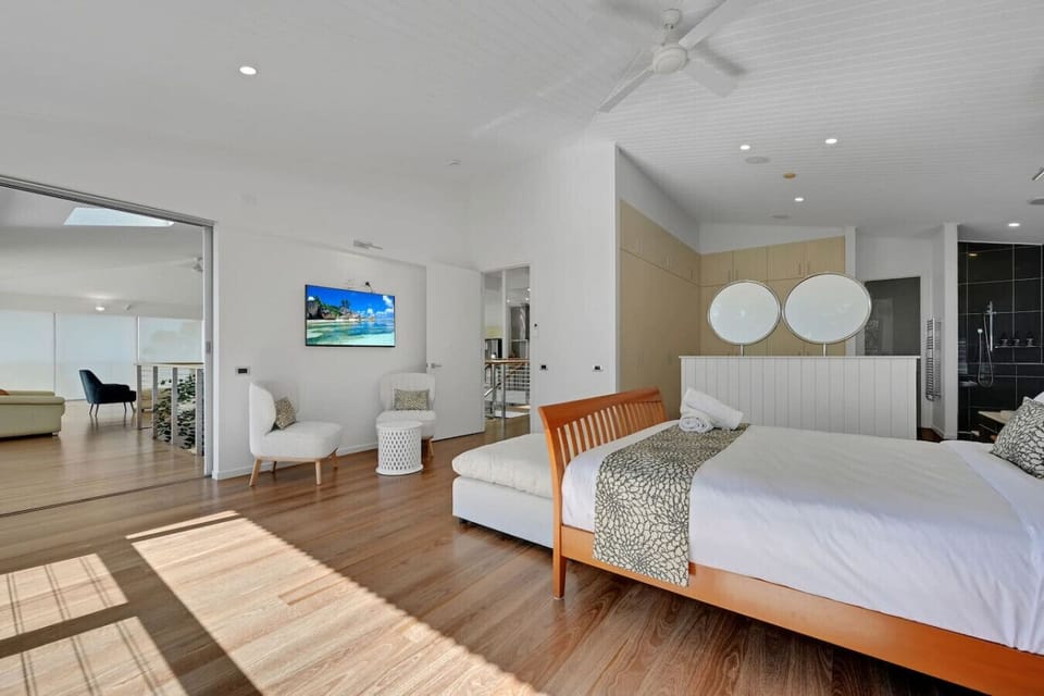 Modern bedroom featuring double bed, seating, TV, and open layout for family comfort.