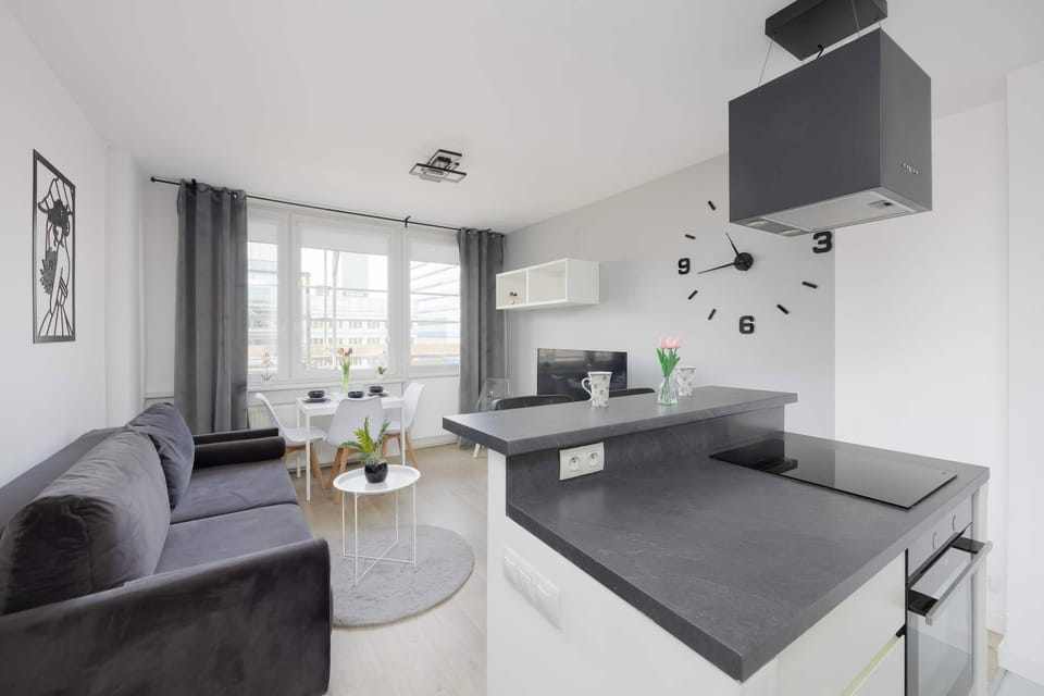 View of the living space highlighting the gray sofa and modern decor. The room is well-lit and thoughtfully arranged. The overall atmosphere is calm and comfortable.