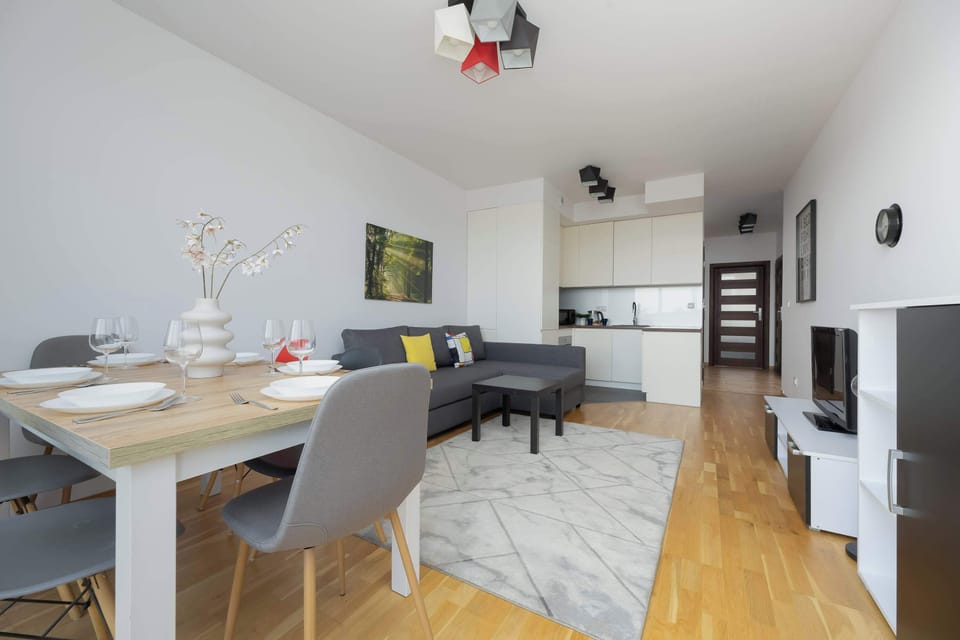 A full interior view captures the transition from the dining and living areas toward the kitchen and hallway. The open layout is functional and well-suited for modern living.