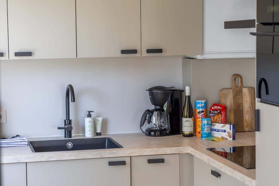 "Modern kitchen with all the essentials – perfect for preparing meals and enjoying your stay. Fully equipped with a coffee maker, sink, and plenty of pantry space!"