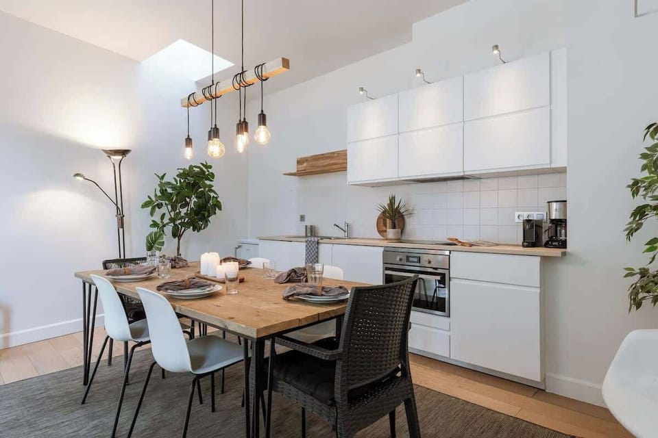 Modern kitchen and dining area with natural wood accents and ambient lighting.
