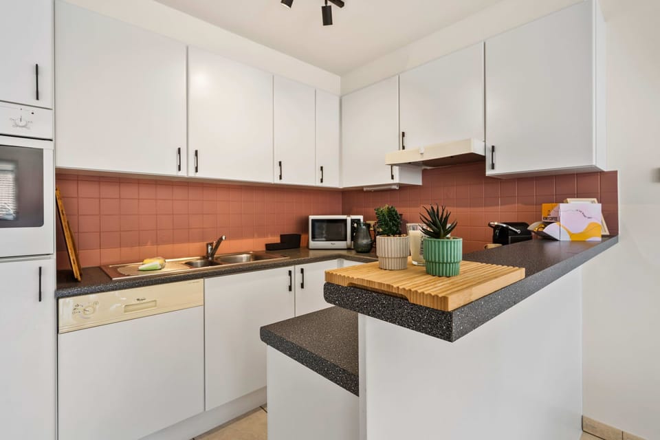 Fully equipped open kitchen featuring modern appliances and a breakfast bar