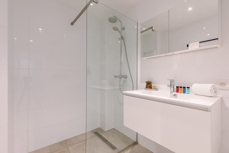 Modern bathroom with a walk-in glass shower and sleek white vanity