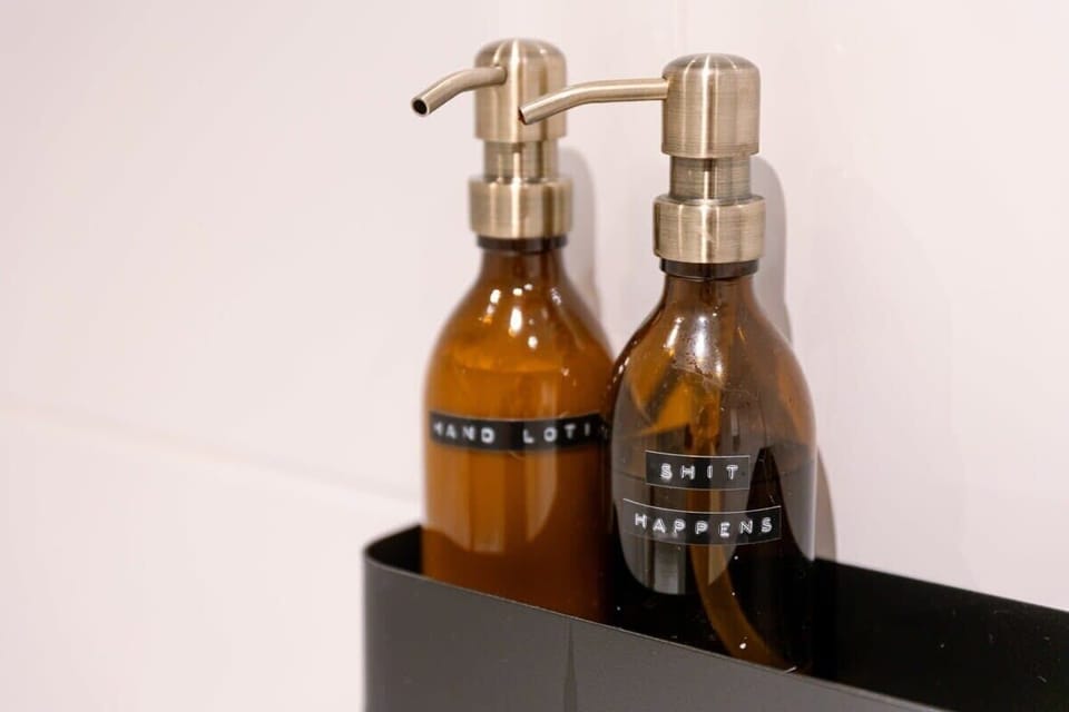 Amber glass dispensers with metal pumps add a modern touch to the bathroom.